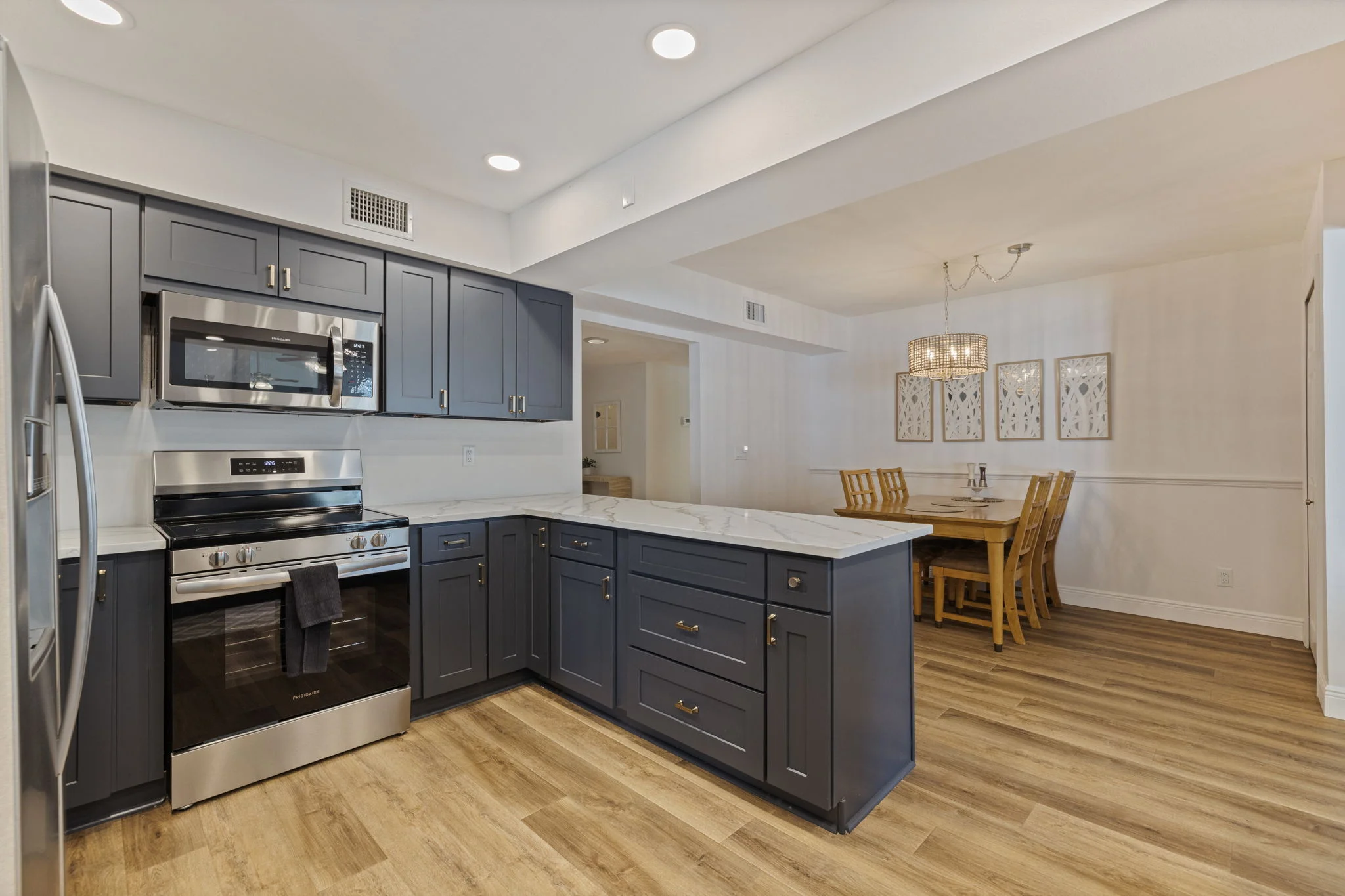 Kitchen with a large island, dark cabinetry, and stainless steel appliances