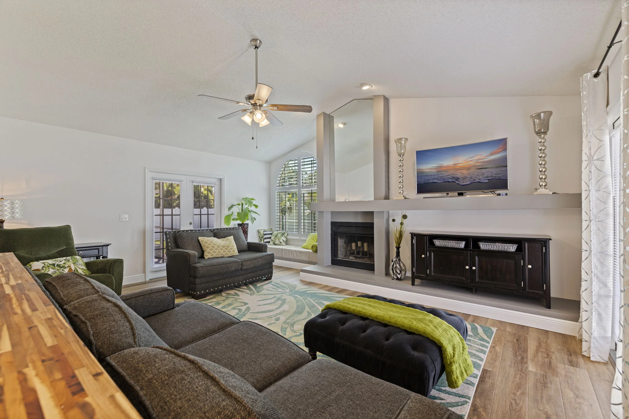 Light-filled living room with a fireplace and tall windows