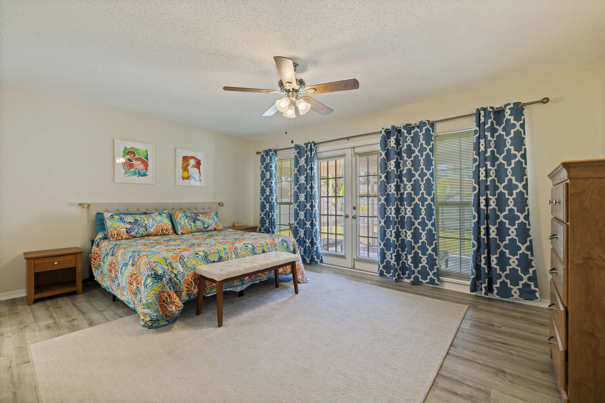 First-floor primary bedroom with windows facing the screened patio